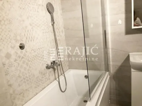 Modern bathroom with bathtub and glass screen. - image 10