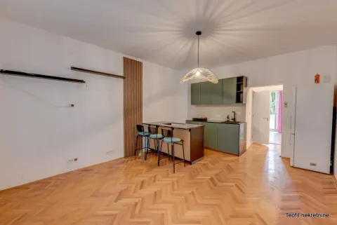 Modern kitchen with a bar counter and bar stools on hardwood flooring. - image 4