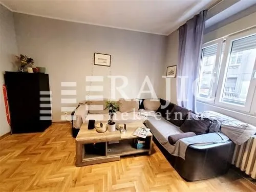 Living room with a sofa set and wooden parquet flooring.