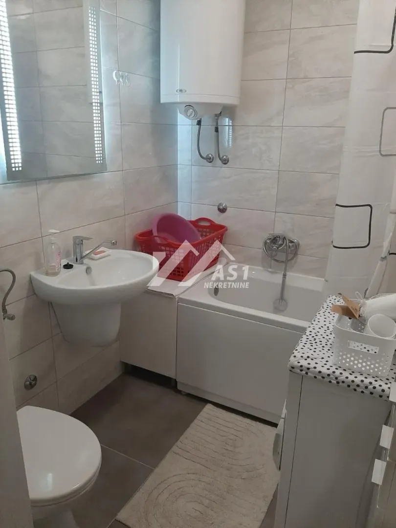 Manje kupatilo opremljeno umivaonikom, kadom, wc šoljom i bojlerom.