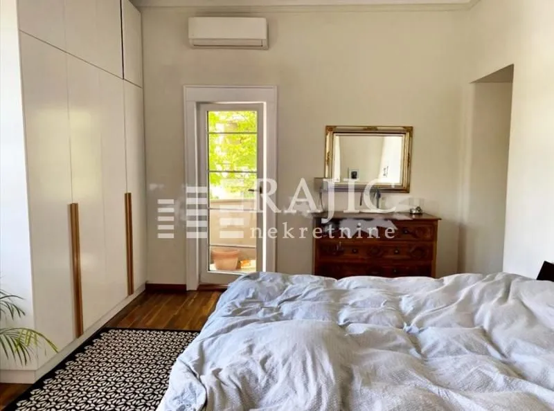Spacious bedroom with a large built-in wardrobe and a double bed.