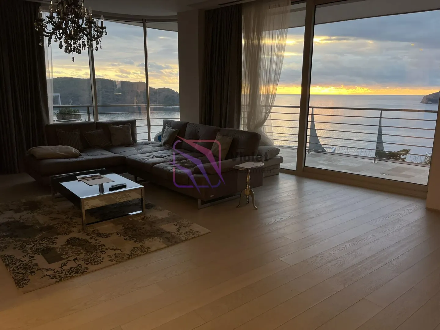 Spacious living room with a sofa and large glass surfaces offering a sea view.