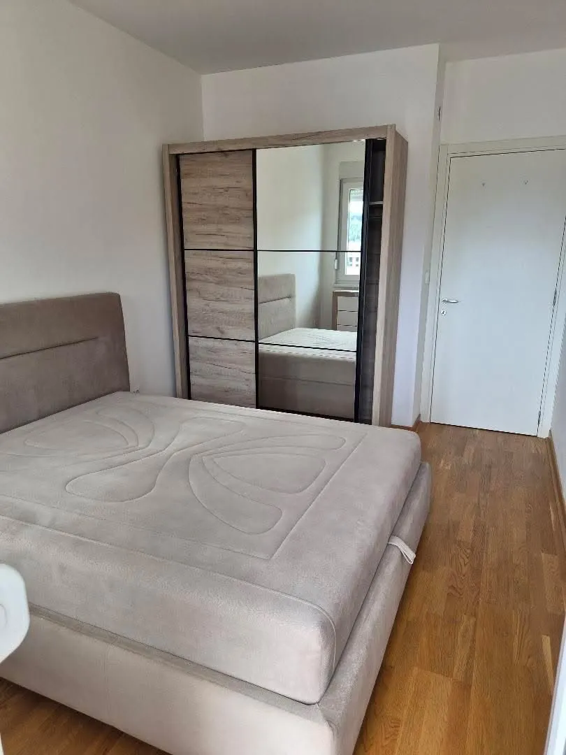 Furnished bedroom with a double bed and a large wardrobe.