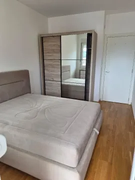 Furnished bedroom with a double bed and a large wardrobe. - image 11