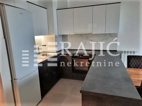 Modern kitchen with dark lower units and white upper cabinets.