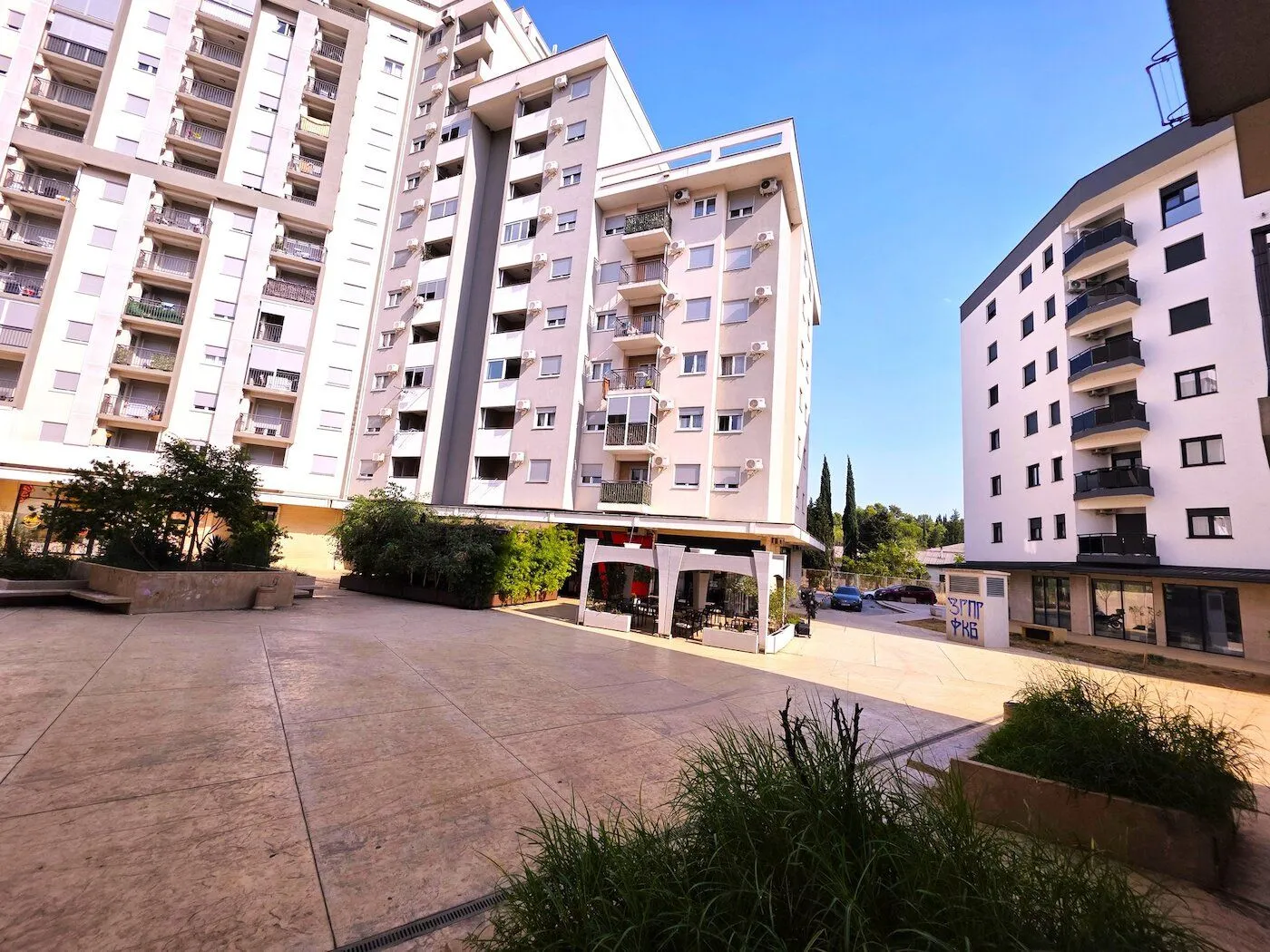Exterior view of the residential building with a paved courtyard.