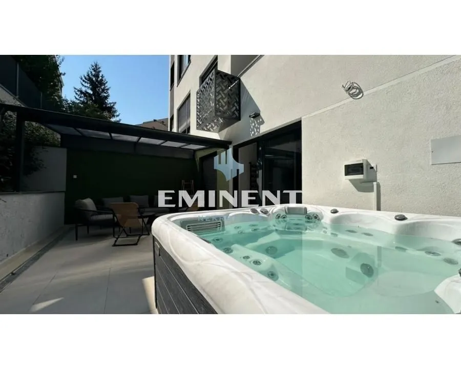 Terrace with a hot tub and seating area in front of the building.