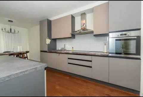 Modern kitchen with built-in appliances and a dining area. - image 2
