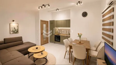 Living room with a sofa set, dining area, and fitted kitchen in the background. - image 3