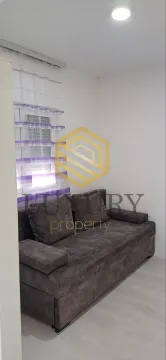 Living room with a sofa and window. - image 10