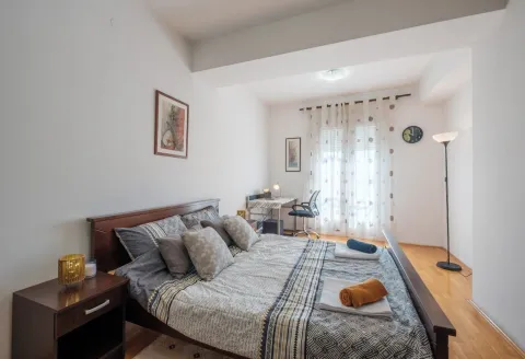 Svijetla spavaća soba sa bračnim krevetom i radnim stolom pored prozora. - image 4