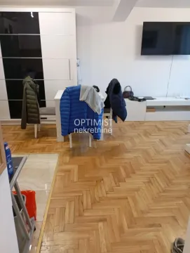 Dnevna soba sa parketom, plakarom i televizorom na zidu. - image 4
