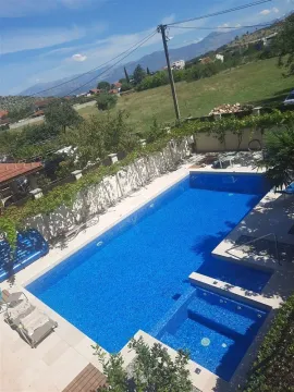 A large outdoor swimming pool in a yard with sun loungers and nature views. - image 2