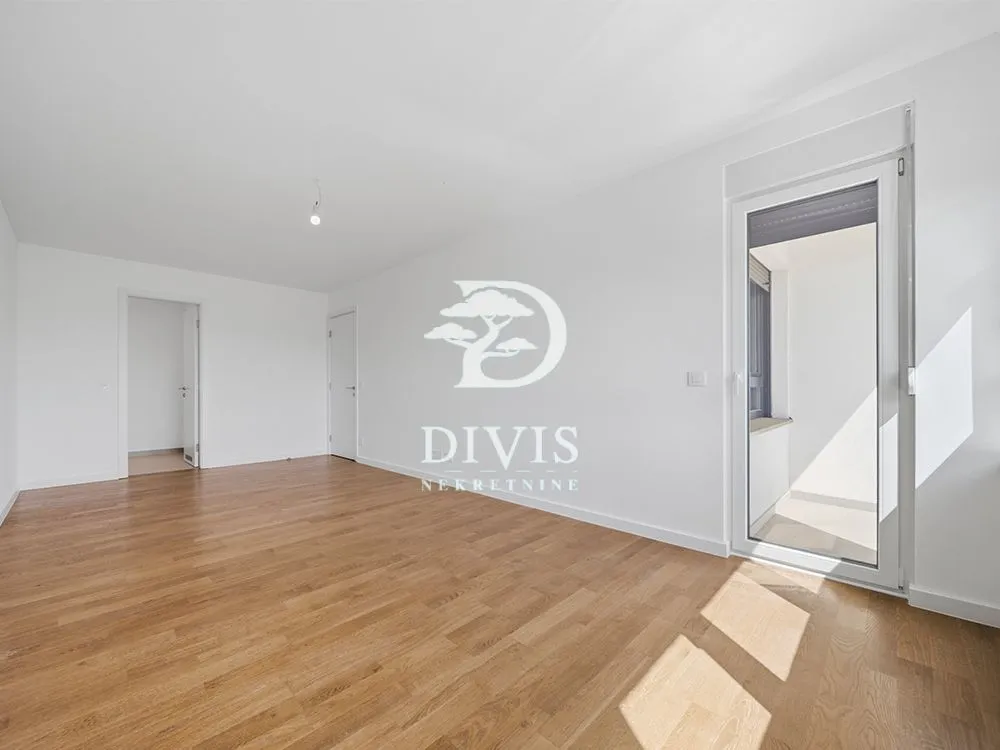 Empty room with wooden flooring and access to a balcony.