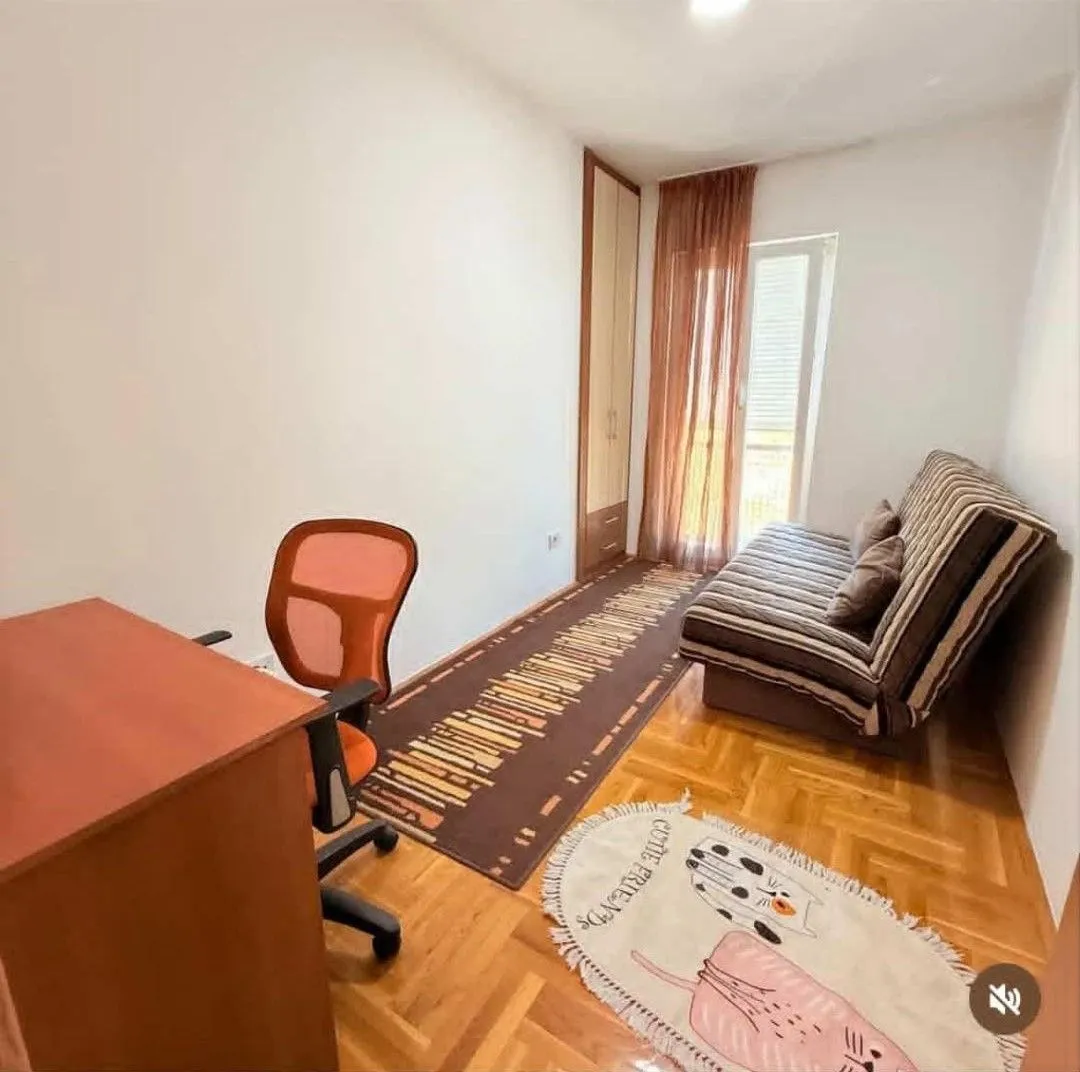 Small bedroom with a sofa bed, a desk, and a wardrobe.