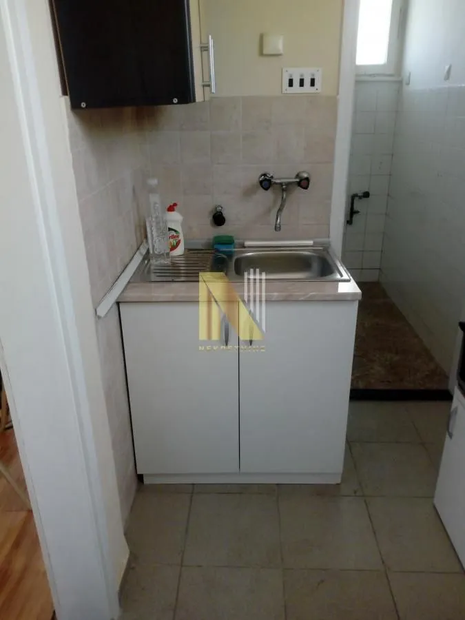 Manja kuhinja sa sudoperom i ugradnim elementima.