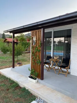 Covered terrace in front of the house with a table and chairs. - image 3