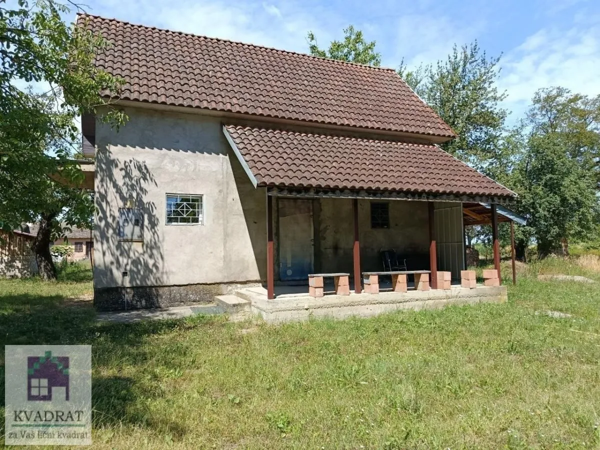 Pogled na spoljašnjost kuće sa natkrivenim tremom i travnatim dvorištem.