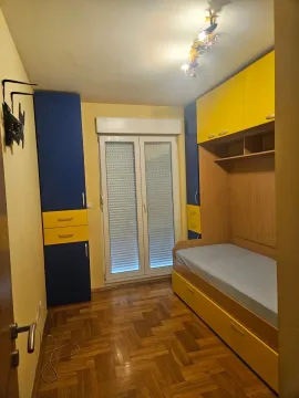 Dječja soba sa krevetom i ugradnim ormarima u žutoj i plavoj boji. - image 4