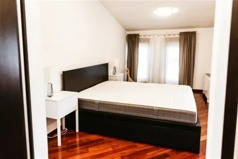 Bright bedroom with a double bed and nightstands. - image 21