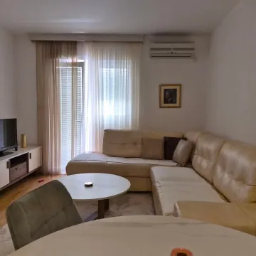 Living room with a sectional sofa, coffee table, and television. - image 4