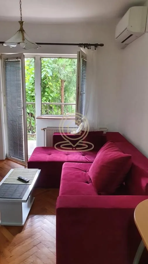 Living room with a red corner sofa and access to the terrace.