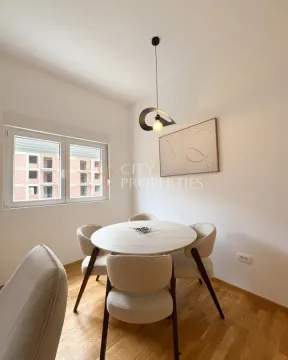 Trpezarija sa okruglim stolom, četiri stolice i modernim lusterom. - image 11