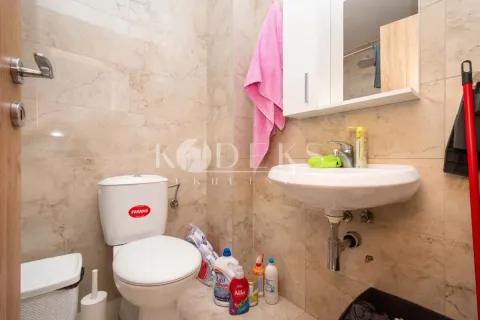 Small bathroom with a toilet, washbasin, and wall cabinet. - image 8
