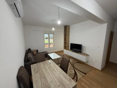 Living room with a sofa, dining table, and TV unit. - image 6
