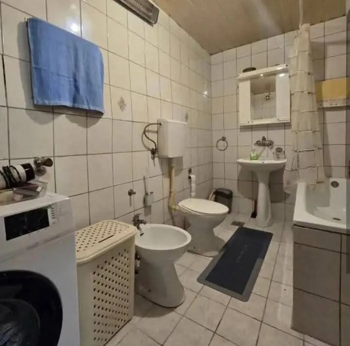 Manje kupatilo sa sanitarijama, tuš kabinom i veš mašinom.