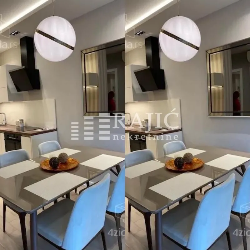 Dining area with a modern table and chairs and a kitchen in the background.