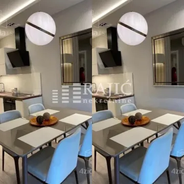 Dining area with a modern table and chairs and a kitchen in the background. - image 7