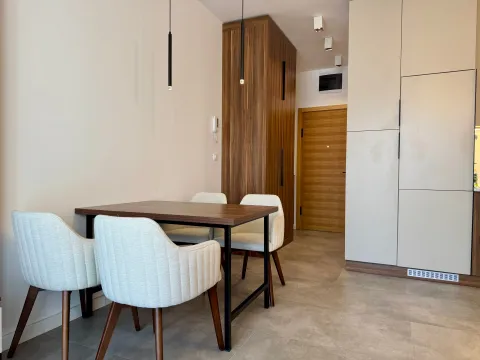 Trpezarija sa drvenim stolom i modernim bijelim stolicama u sklopu kuhinje. - image 7