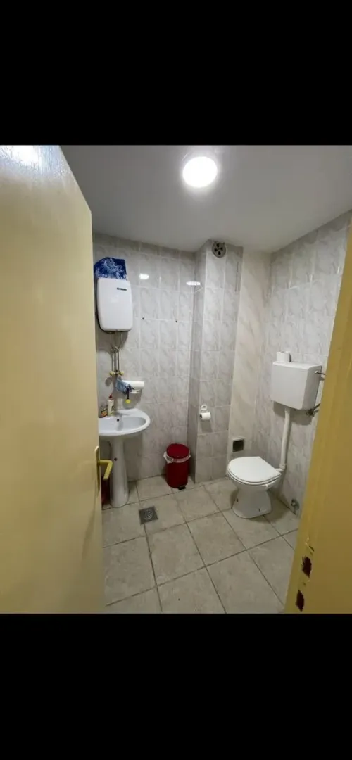 Smaller bathroom with tiling, washbasin, and toilet.