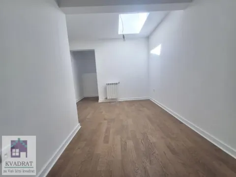 Empty room with white walls, wooden flooring, and a skylight. - image 9
