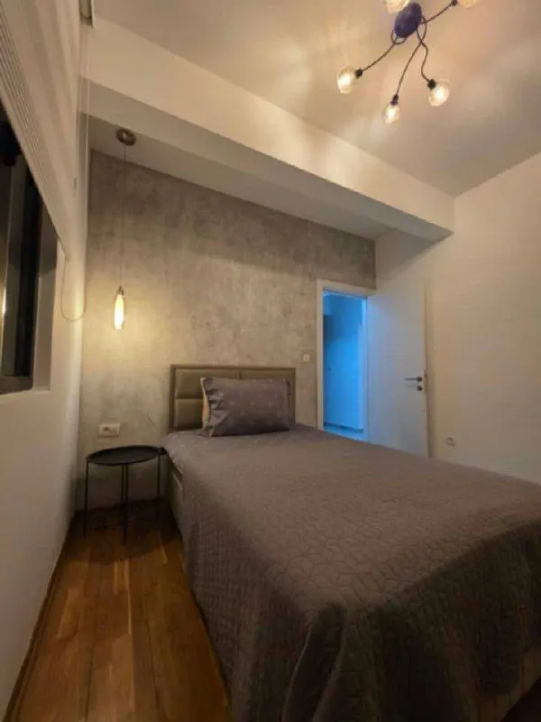 Furnished bedroom with a bed and modern lighting.