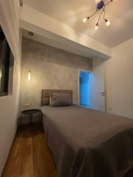 Furnished bedroom with a bed and modern lighting. - image 9