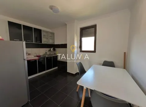Kitchen equipped with black cabinets and a dining table. - image 5