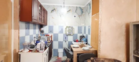 Smaller kitchen with a dining table and wall tiles. - image 4
