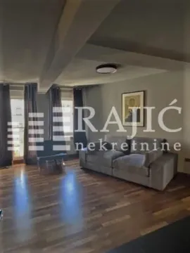 Spacious living room with a sofa and wooden flooring. - image 2