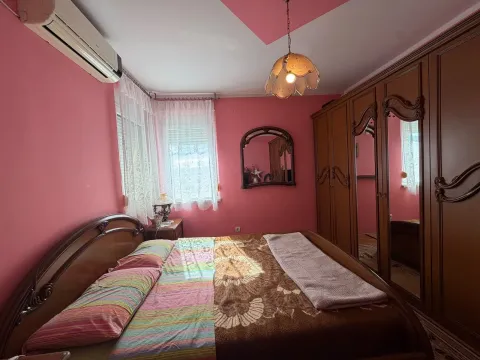 A bedroom with a double bed, wooden wardrobe, and pink walls. - image 6