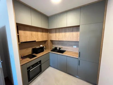 Moderna kuhinja sa sivim elementima i radnim površinama u boji drveta. - image 6
