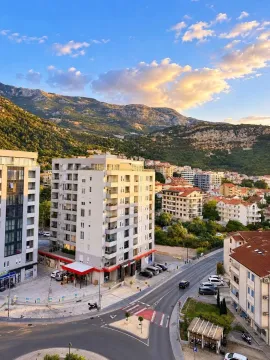 Pogled sa prozora na gradsko naselje i planine u pozadini. - image 2