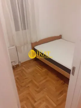 Manja spavaća soba sa krevetom, drvenim parketom i prozorom. - image 7