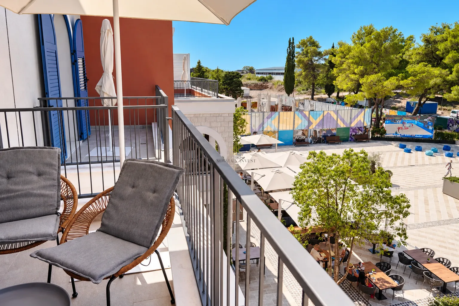 Namješten balkon sa garniturom za sjedenje i pogledom na trg.