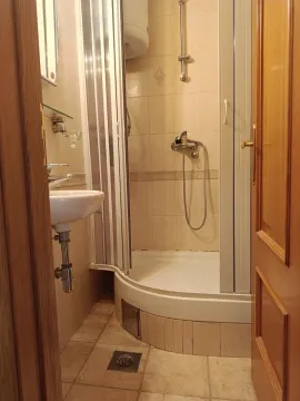 Small bathroom with a shower cabin and a washbasin. - image 9