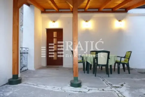 Natkrivena terasa ispred ulaza u kuću sa garniturom za sedenje. - image 9