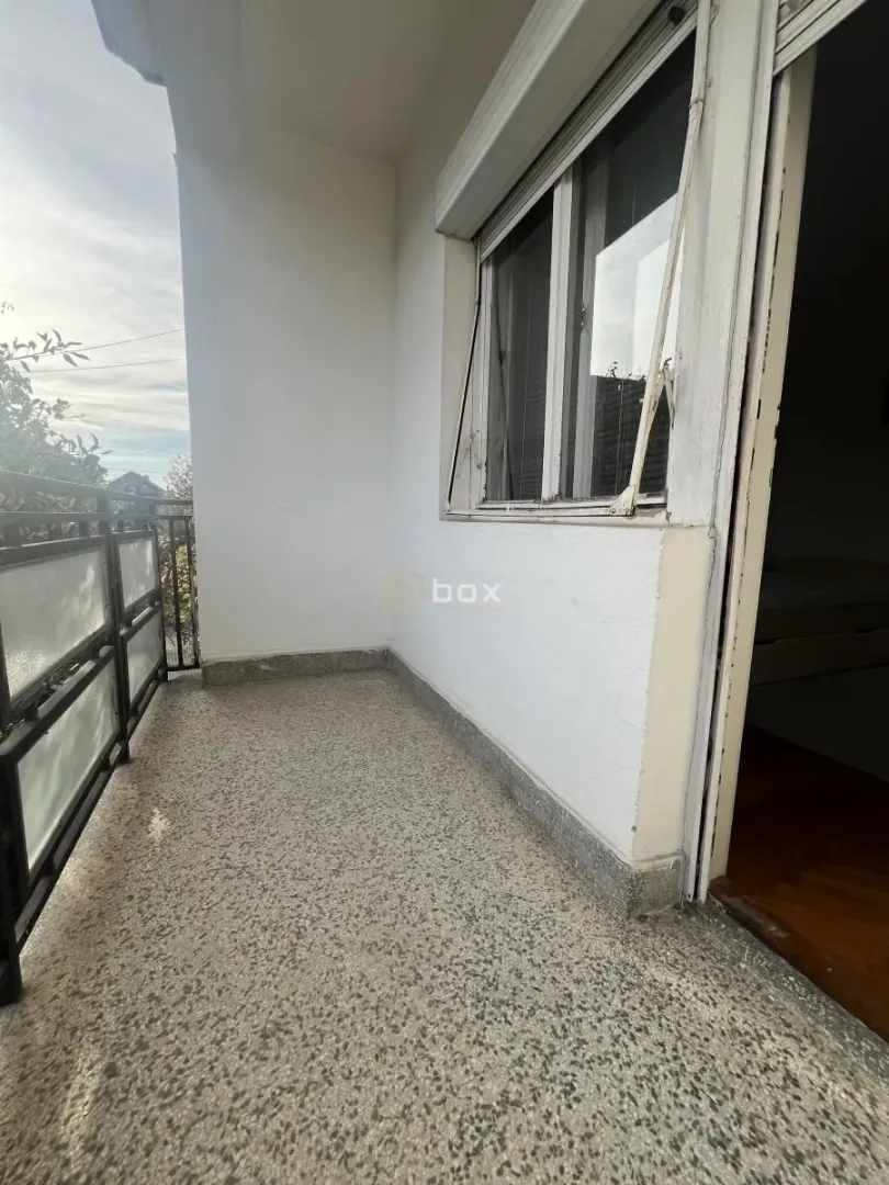 Manji natkriveni balkon sa ogradom i pogledom na okolinu.