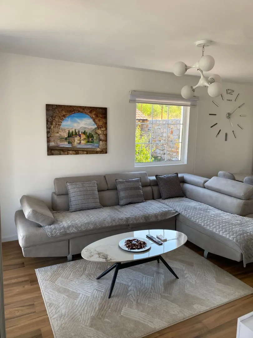 Bright living room with a sectional sofa, coffee table, and modern chandelier.