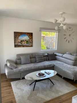 Bright living room with a sectional sofa, coffee table, and modern chandelier. - image 8